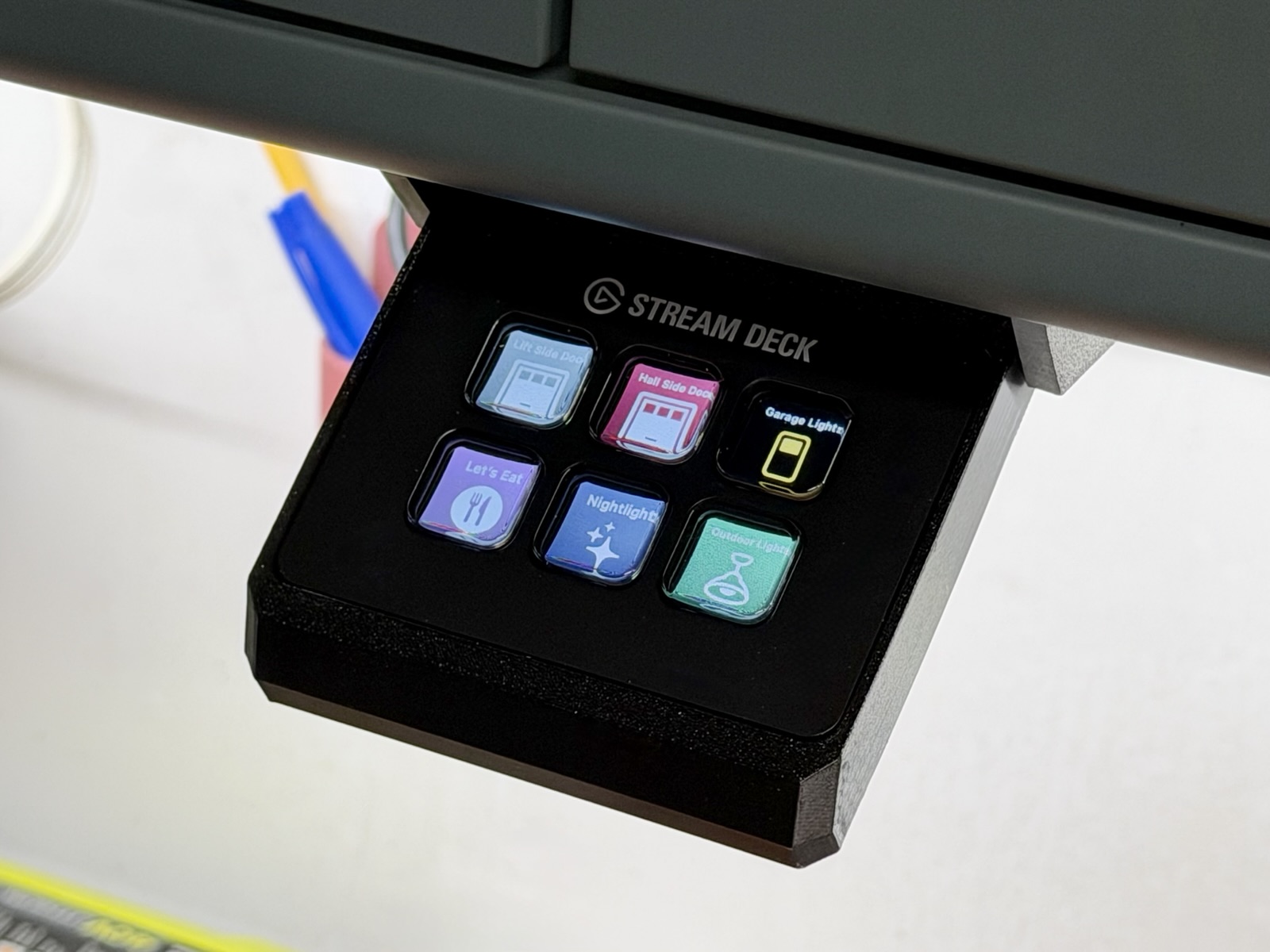 A Stream Deck Mini mounted under a shelf, showing six HomeKit keys.
